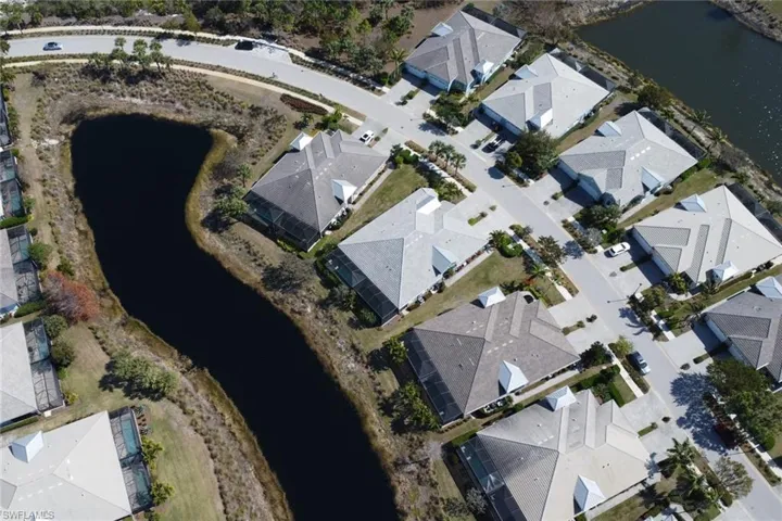 Aerial view of property and surrounding area with a large body of water and nearby suburban area