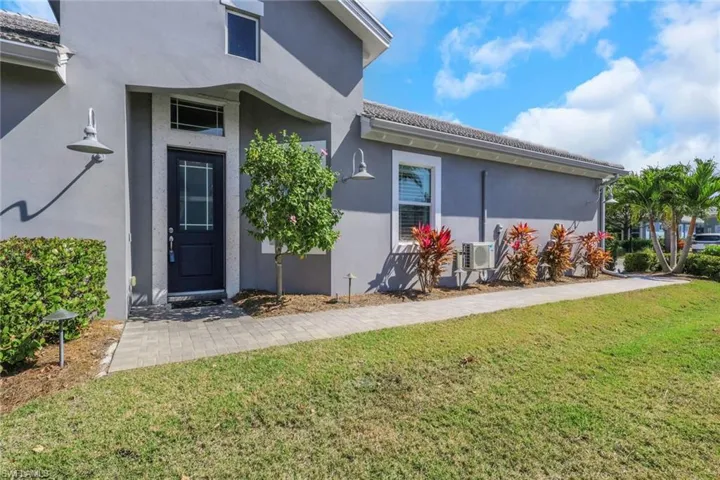 Entrance to property with a yard and stucco siding