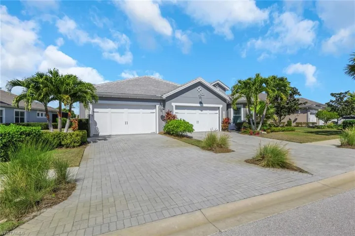 Ranch-style home with stucco siding, decorative driveway, a tiled roof, and an attached garage