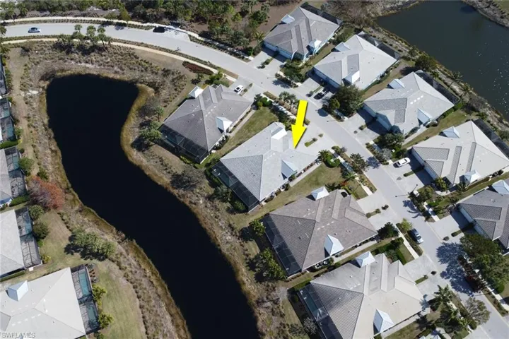 Aerial view of property and surrounding area featuring a nearby body of water and nearby suburban area
