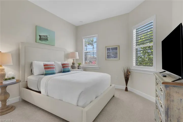 Bedroom featuring baseboards and light colored carpet