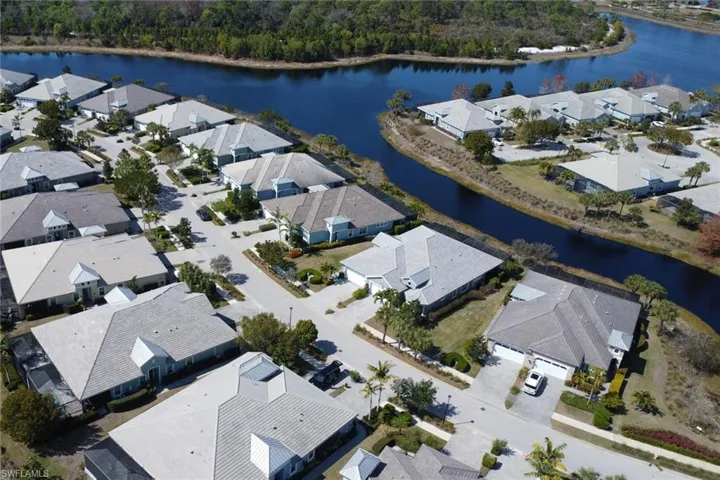 Aerial view of property and surrounding area featuring a nearby body of water and nearby suburban area