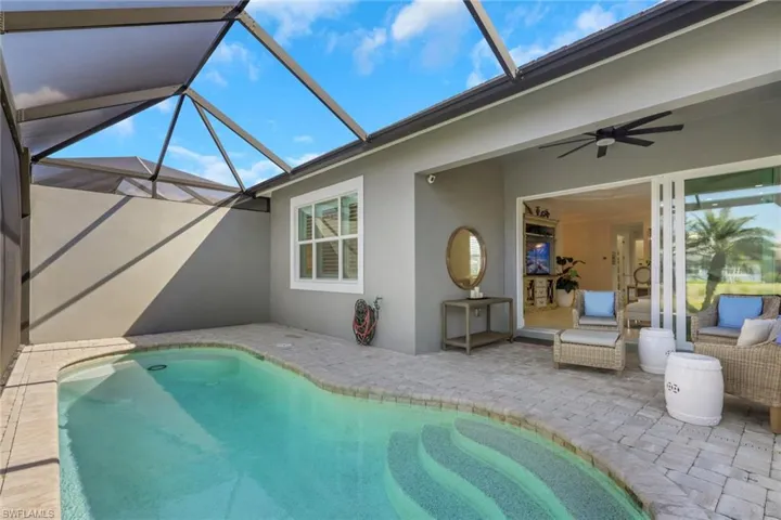 Outdoor pool featuring a sunroom, a patio area, and a lanai
