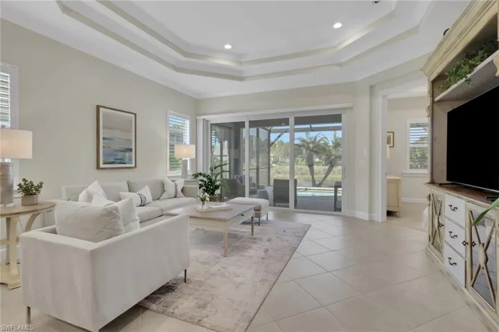 Living room with crown molding, plenty of natural light, light tile patterned flooring, and recessed lighting