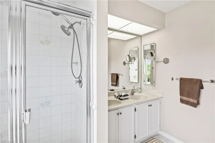 Bathroom featuring double vanity and an enclosed shower