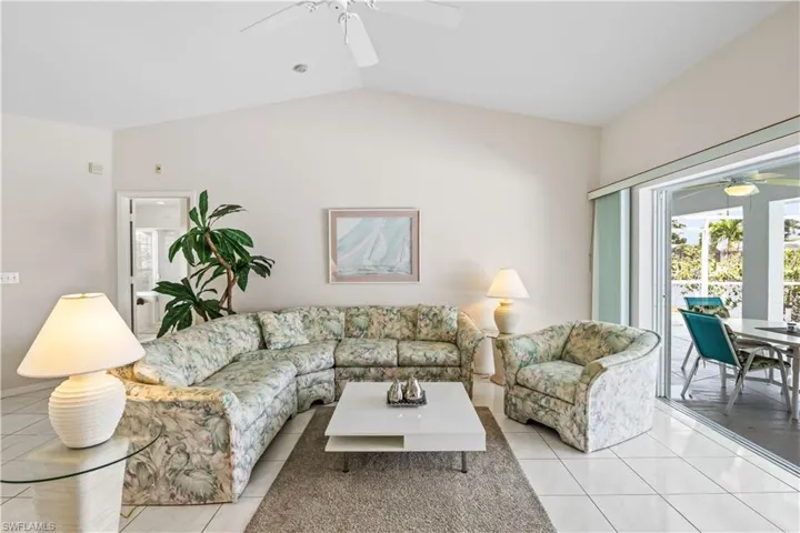 Tiled living room with vaulted ceiling and ceiling fan