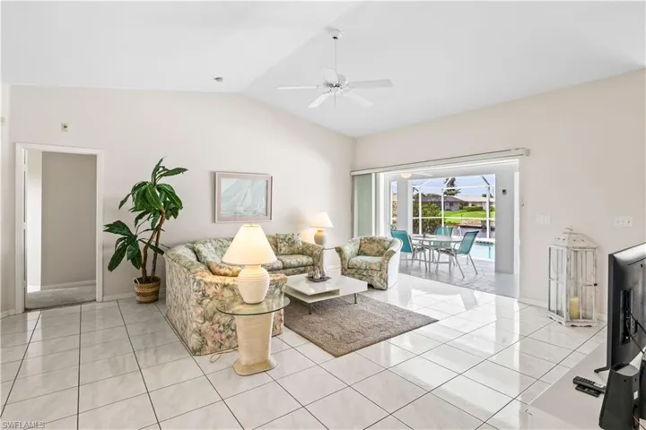 Tiled living room featuring lofted ceiling and ceiling fan