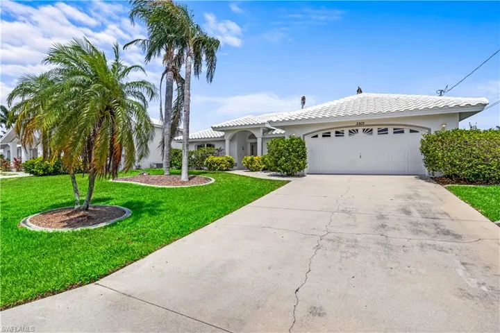 View of front of house with a garage and a front lawn