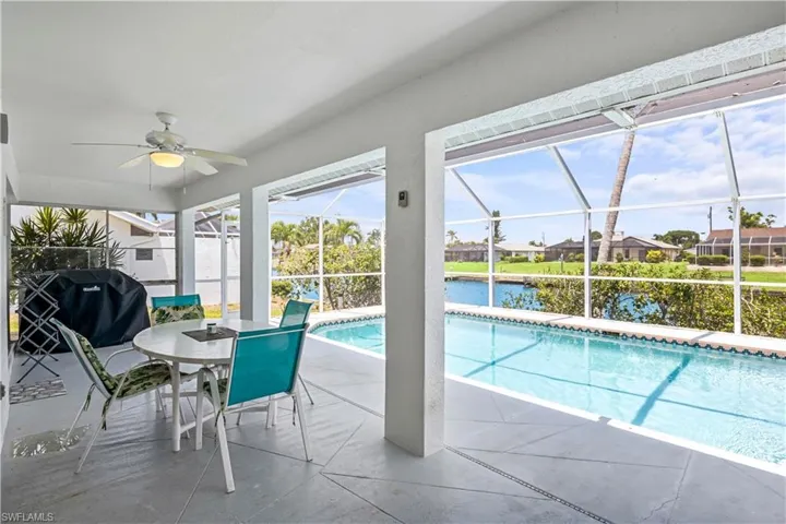View of pool with a patio area, grilling area, a lanai, and ceiling fan