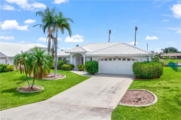 Mediterranean / spanish-style home with a front yard and a garage