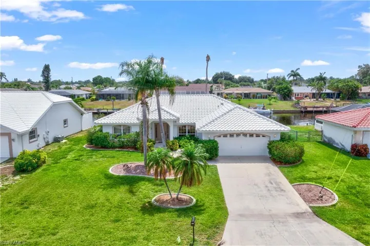 View of front of home featuring a front lawn and a garage