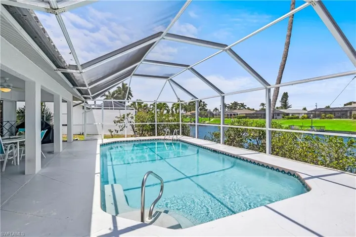 View of swimming pool with a patio and glass enclosure