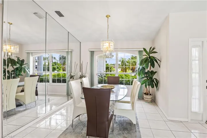 Dining space with a chandelier, light tile flooring, and lofted ceiling