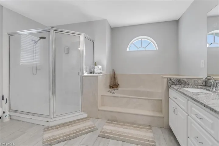 Bathroom featuring separate shower and tub, vanity, and wood-type flooring