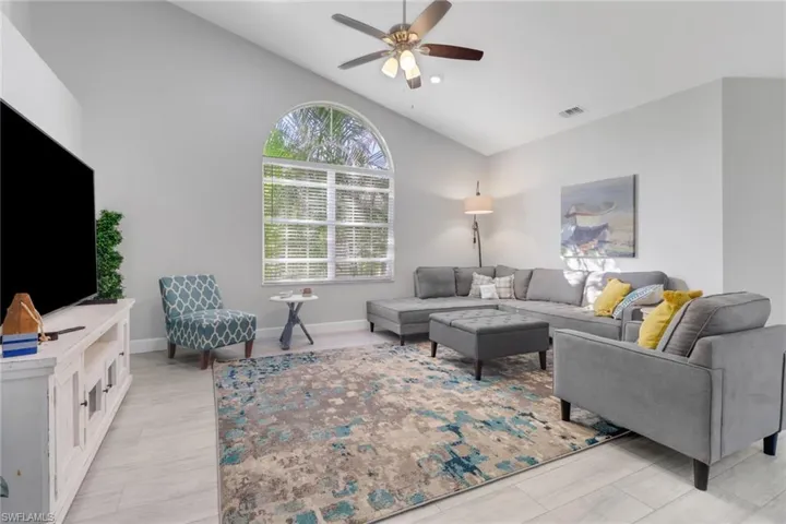 Living room featuring ceiling fan and vaulted ceiling