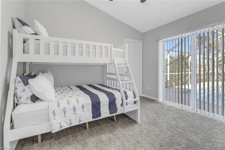 Bedroom with carpet floors, access to outside, vaulted ceiling, and ceiling fan
