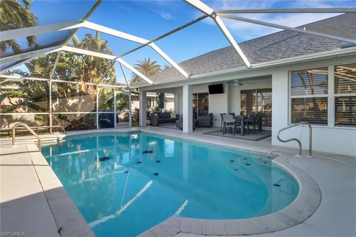 View of pool featuring outdoor lounge area, glass enclosure, ceiling fan, and a patio area