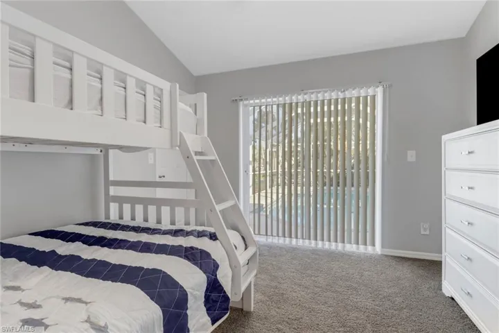 Bedroom featuring access to exterior, carpet floors, and lofted ceiling