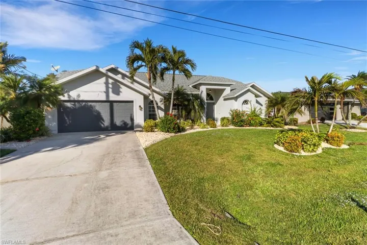 View of front of home featuring a garage and a front lawn