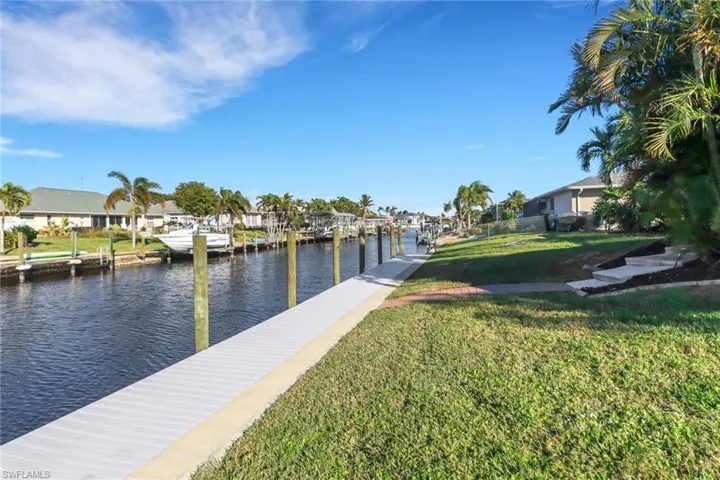 View of dock featuring a water view and a lawn