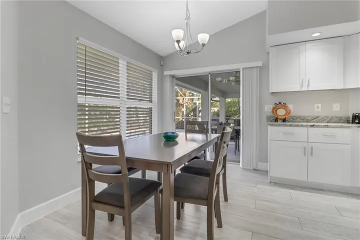 Dining area featuring a chandelier, lofted ceiling, and light hardwood / wood-style floors
