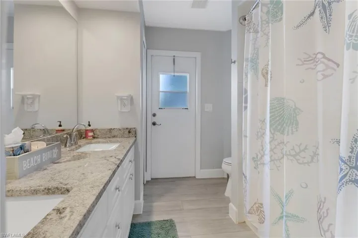 Bathroom with vanity, hardwood / wood-style flooring, and toilet