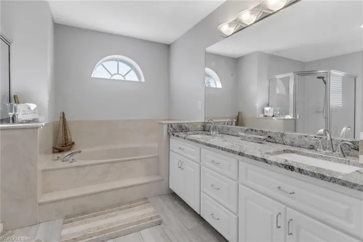Bathroom featuring vanity and shower with separate bathtub