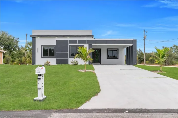 Contemporary home with stucco siding, a front lawn, concrete driveway, and a carport