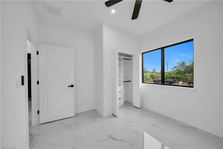 Unfurnished bedroom featuring light marble finish floors, a closet, ceiling fan, and recessed lighting
