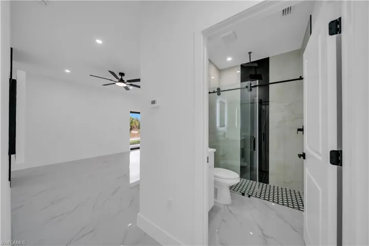 Full bathroom with light marble finish floors, a marble finish shower, recessed lighting, and ceiling fan