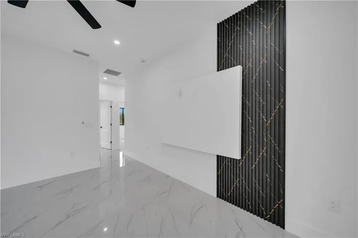 Empty room with marble tiled floors, recessed lighting, and ceiling fan