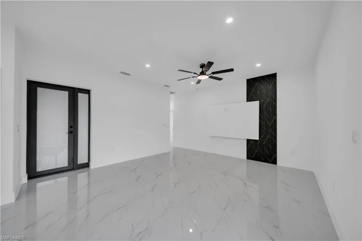 Empty room featuring light marble finish floors, recessed lighting, a ceiling fan, and french doors