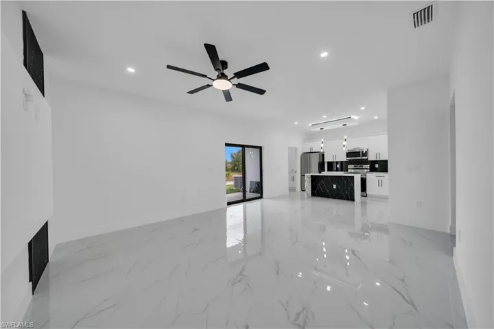 Unfurnished living room with recessed lighting, light marble finish floors, and ceiling fan