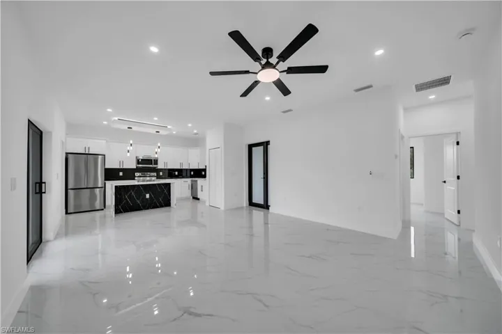 Unfurnished living room featuring recessed lighting, light marble finish flooring, and ceiling fan