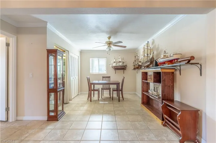 Dining space featuring crown molding, light tile patterned flooring, ceiling fan, and baseboards