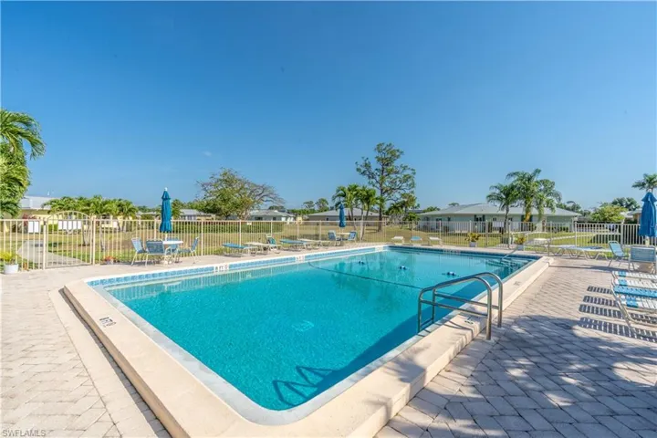 Community pool with a patio and fence