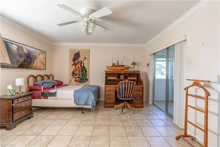 Bedroom with baseboards, light tile patterned floors, ornamental molding, and ceiling fan