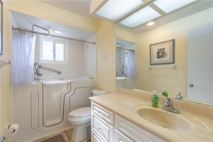 Full bathroom featuring vanity, a washtub, tile patterned floors, toilet, and walk in shower