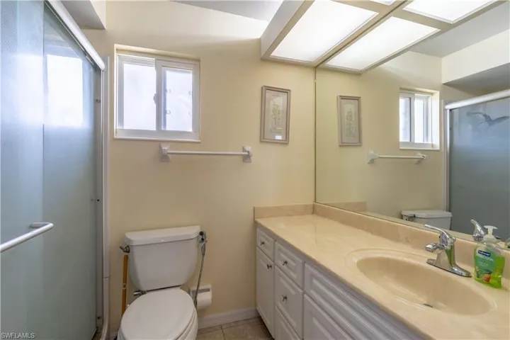 Full bath with a shower stall, toilet, tile patterned flooring, and vanity