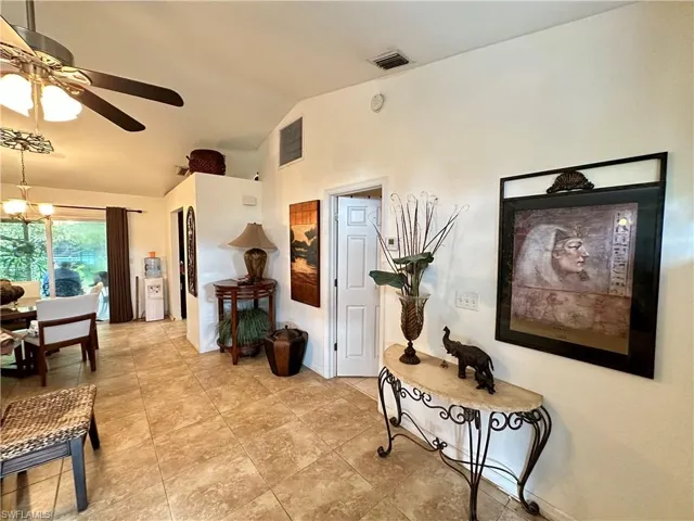 Hall featuring vaulted ceiling and a notable chandelier