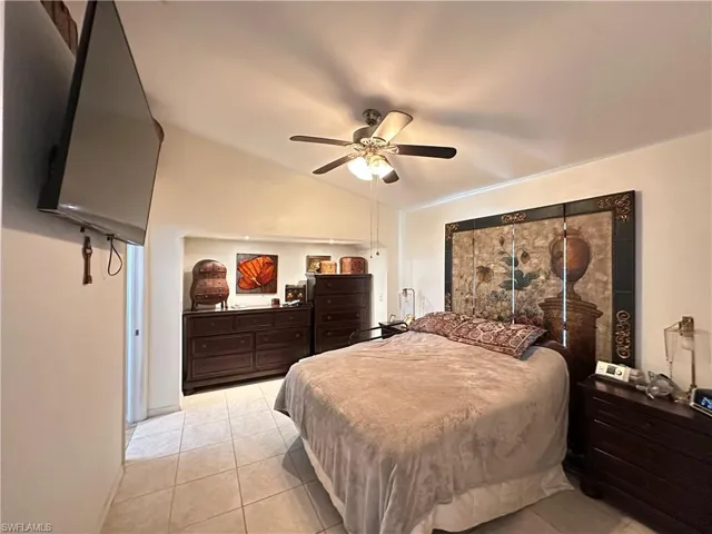Bedroom featuring lofted ceiling, ceiling fan, and light tile patterned floors