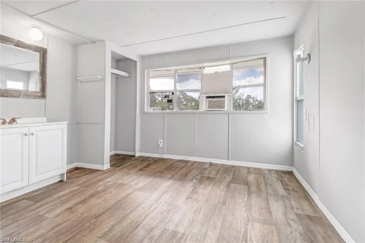 Unfurnished bedroom featuring a closet, cooling unit, and light hardwood / wood-style flooring