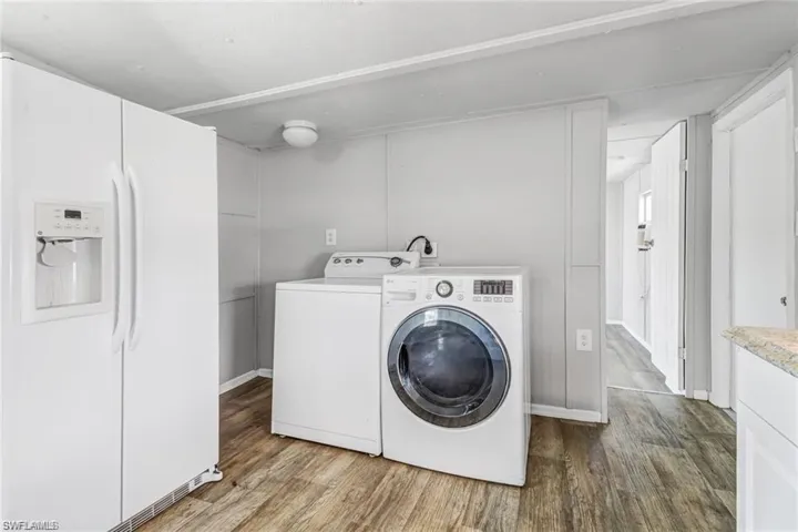 Clothes washing area with separate washer and dryer and hardwood / wood-style flooring