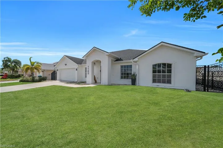 Ranch-style home with concrete driveway, a front yard, stucco siding, and a garage