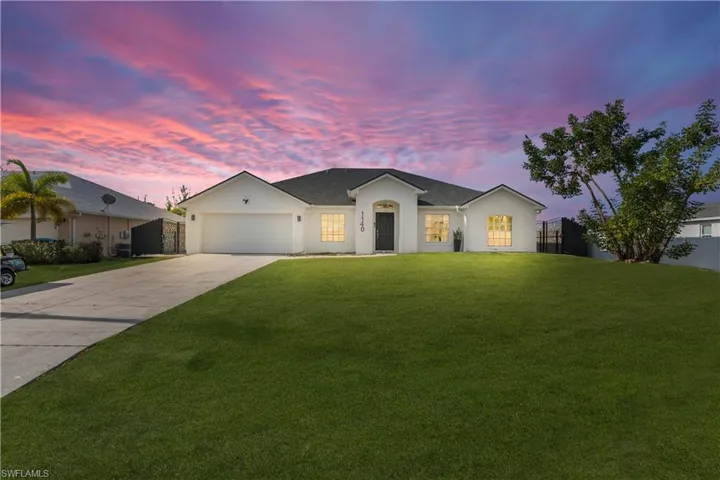 Single story home with driveway, stucco siding, and an attached garage