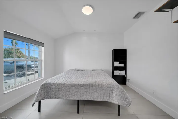 Bedroom featuring lofted ceiling and light tile patterned flooring