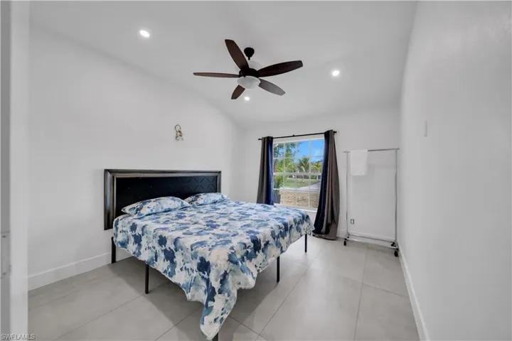 Bedroom with vaulted ceiling, a ceiling fan, and recessed lighting