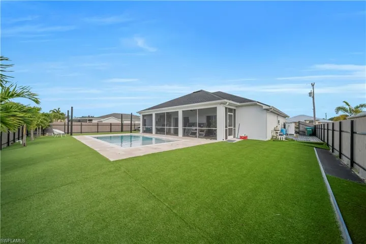 Rear view of house with a sunroom, a fenced backyard, a patio area, and stucco siding