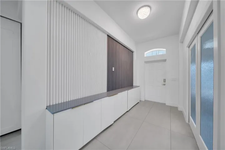 Hallway featuring light tile patterned flooring and baseboards