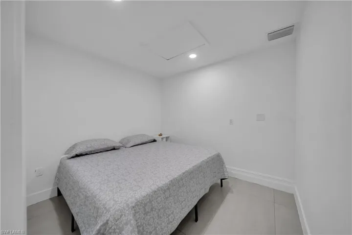 Bedroom featuring attic access, recessed lighting, and light tile patterned floors